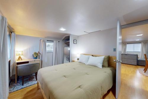 a bedroom with a large bed with a desk and a room with at Shore Pine Cottage in Grayland