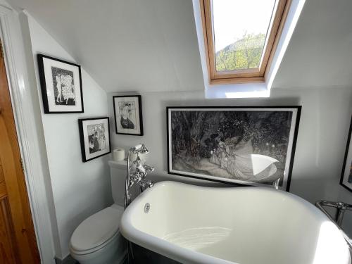 a bathroom with a bath tub and a toilet at Clachan Garden B&B in Garve
