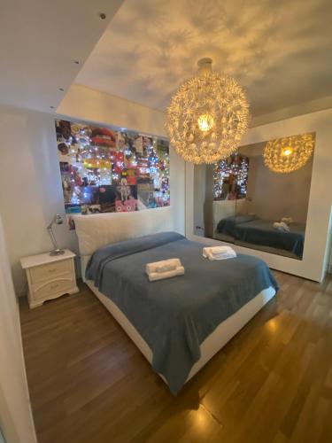 a bedroom with a large bed and a chandelier at Blue Zen beachfront apartment in Civitanova Marche