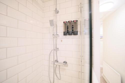 a shower in a white tiled bathroom at 1 Bedroom Apartment By Travel Lets Holiday Homes Derry Beside The City Walls in Derry Londonderry