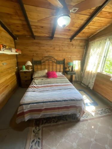 a bedroom with a bed in a log cabin at Las calandrias in Barrio Copacabana