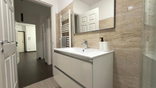 a white bathroom with a sink and a mirror at Urban Nest Living in Sesto San Giovanni
