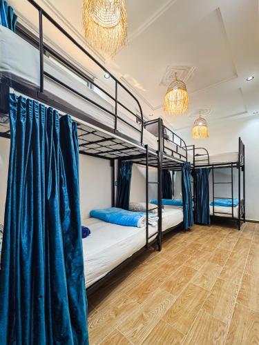a room with two bunk beds and a wooden floor at Blue Pearl Surf & Yoga House in Tamraght Ou Fella