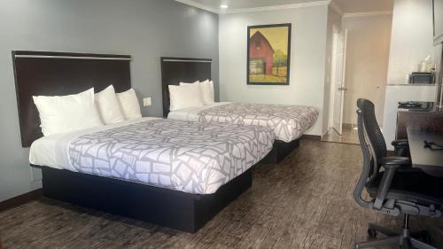 a hotel room with two beds and a desk at Laguna Inn and Suites in San Juan Capistrano
