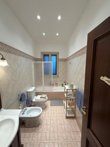 a bathroom with two toilets and a sink and a tub at La casa di Nerone in Acireale