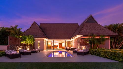 a villa with a swimming pool at night at InterContinental Fiji Golf Resort & Spa by IHG in Natadola