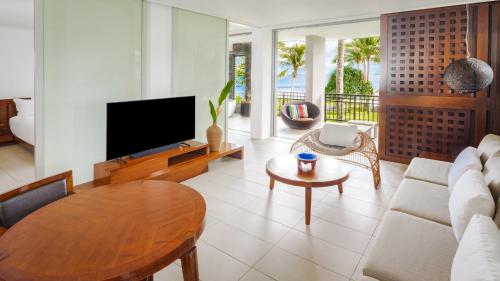 a living room with a television and a table at InterContinental Fiji Golf Resort & Spa by IHG in Natadola