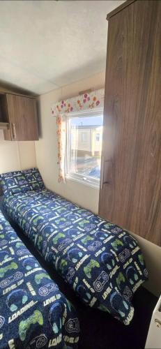 a bedroom with two beds and a window at BILOT Caravan in Heysham