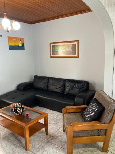 a living room with a black couch and a coffee table at Casa da Baía da Manhenha in Manhenha