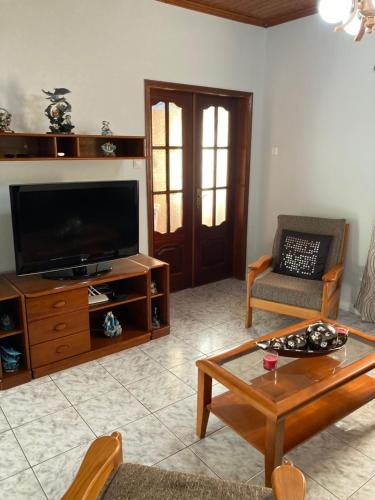 a living room with a television and a coffee table at Casa da Baía da Manhenha in Manhenha