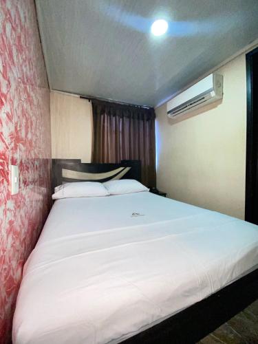 a bedroom with a large white bed in a room at Hotel Mi Palermo in Bucaramanga