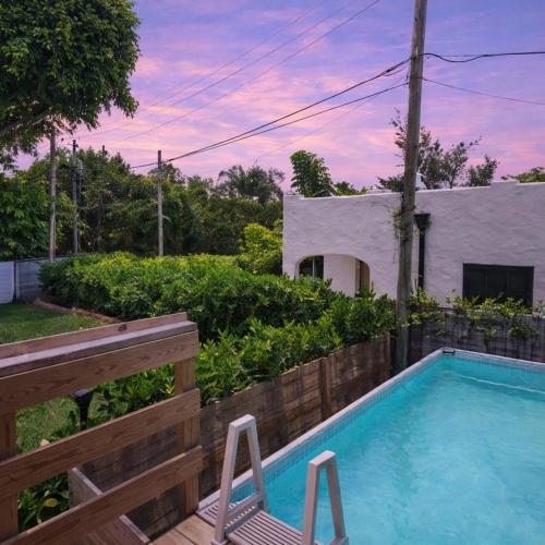a swimming pool with two chairs next to a house at Elegant 3BR w Pool Near Downtown WPB in West Palm Beach