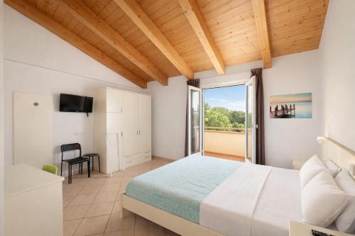 ein Schlafzimmer mit einem Bett und einem großen Fenster in der Unterkunft Hotel Sasselli Dipendenza Hotel Zamagna in Cesenatico