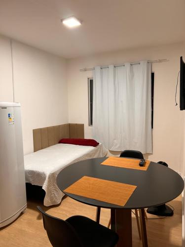 a room with a bed and a table and chairs at Apartamento Loft in Balneário Camboriú
