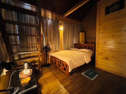 a bedroom with a bed in a wooden room at Orelia villas in Badulla