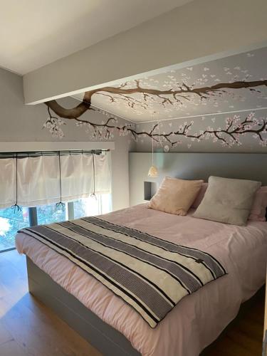 a bedroom with a bed with a painting on the ceiling at La P'tite Bicoque in Doizieux