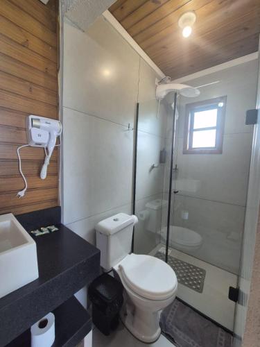 a bathroom with a toilet and a shower and a sink at Cabanas das Oliveiras in Torres