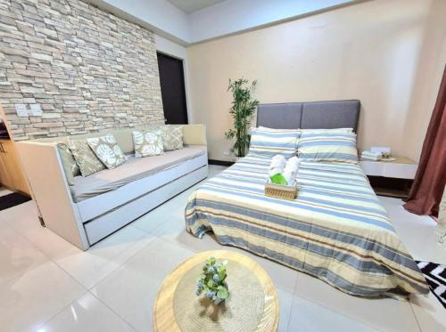 a living room with a bed and a couch at STUDIO TYPE CEBU CITy in Cebu City