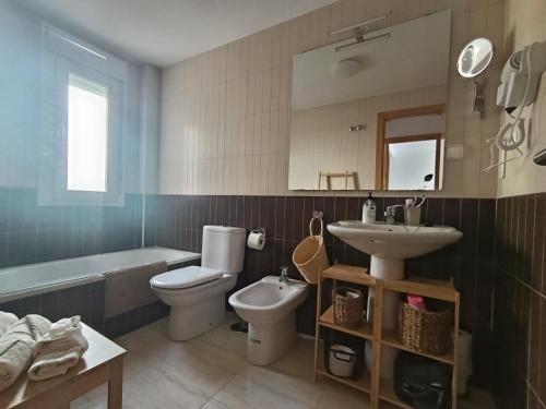 a bathroom with a toilet and a sink and a tub at ALMERIMAR GOLF AND PoOL APARTMENT in Almerimar