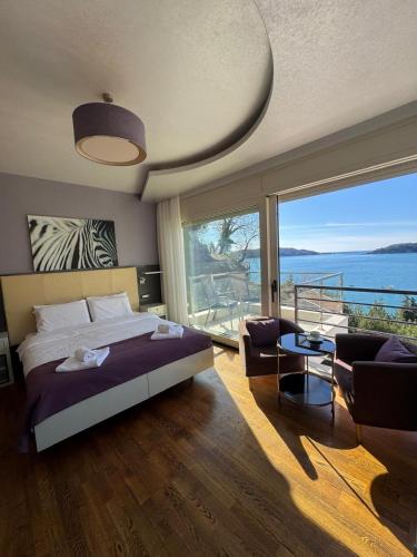 a bedroom with a bed and a view of the ocean at Meridian Hotel in Budva