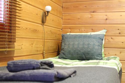 a bedroom with a bed with a pillow and a phone at Scandinavian Dream Cottages Vikajarvi- Rovaniemi in Vikajärvi