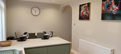 a room with a table and a clock on the wall at Martindale Close - 3 Bedrooms - Sleeps 5 in Whitehaven