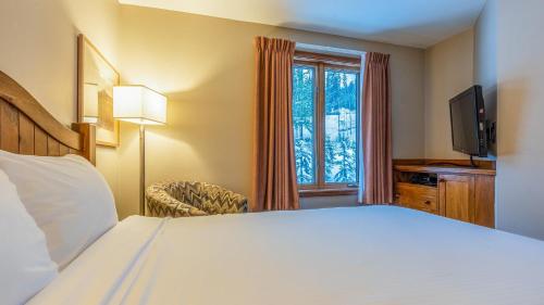 a hotel room with a bed and a window at Cahilty #225 home in Sun Peaks