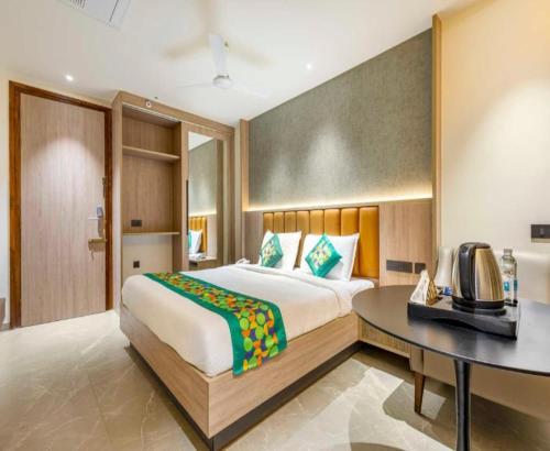 a bedroom with a bed and a desk and a television at The Kalvin Plaza in New Delhi