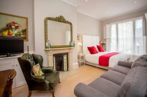 a living room with a couch and a bed and a mirror at Blenheim House - Luxury City Centre Georgian Townhouse for 8 in Bath