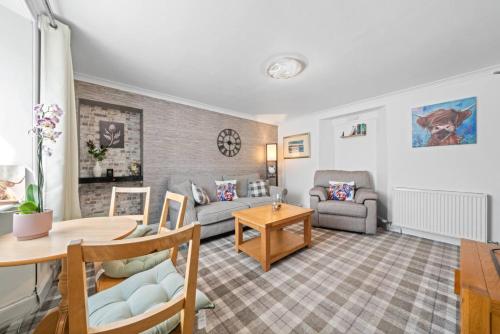 a living room with a couch and a table at Cloudhowe Cottage Ensuite Rooms & Studio Inverness in Inverness