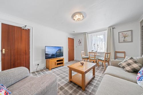 a living room with a couch and a table at Cloudhowe Cottage Ensuite Rooms & Studio Inverness in Inverness