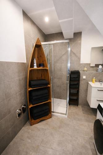 a bathroom with a shower and a wooden shelf at Ferienwohnung Niki am Straussee Seeblick und Kamin für bis zu 12 Personen in Strausberg