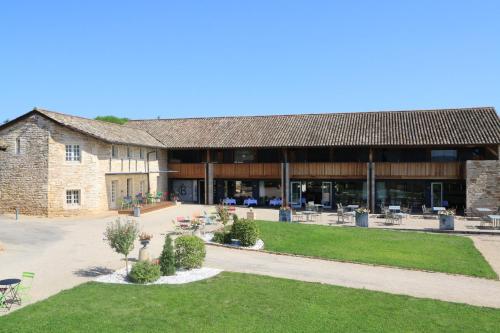 a large brick building with a lawn in front of it at Teritoria Château de Besseuil in Clessé