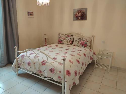 a bedroom with a white bed with a floral bedspread at Roz Aon in Châteauneuf-du-Faou