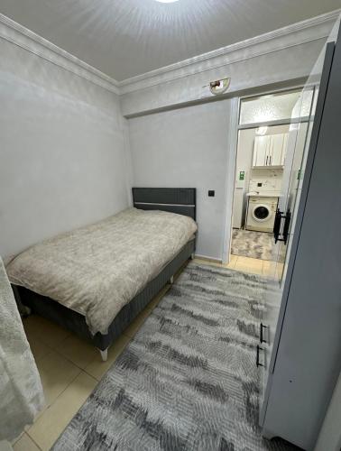 a small bedroom with a bed and a bathroom at Ozan Konukevi in Hatay
