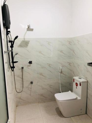 a bathroom with a shower and a toilet in it at Kahanda Cinnamon Villa in Angulugaha