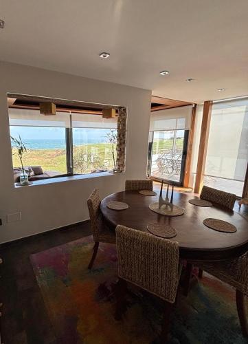 a dining room with a table and chairs and a view of the ocean at Villa Suances in Tagle