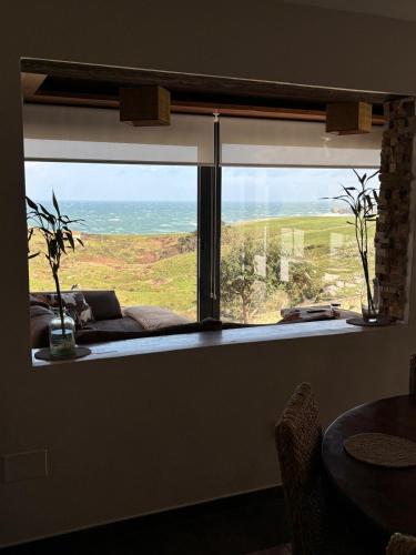 a window in a room with a view of the ocean at Villa Suances in Tagle