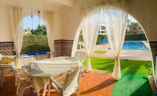 a room with a tent with a pool and a table at Luxuriöses Chalet mit privatem Pool in Roquetas de Mar