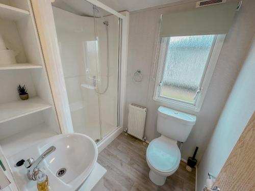 a bathroom with a toilet and a sink and a shower at The Bay Hideaway in Bucks Mills