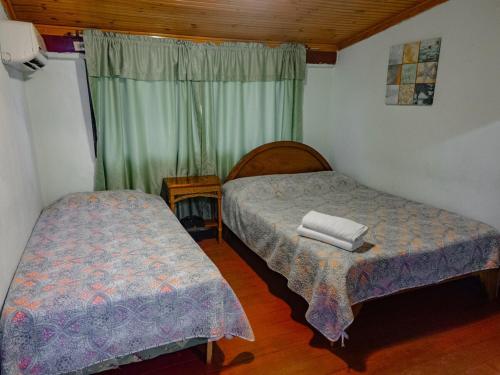 a bedroom with two beds and a window at Casa Rector - Beach House Rental in El Roble