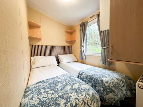 a small room with two beds and a window at The Bay Hideaway in Bucks Mills