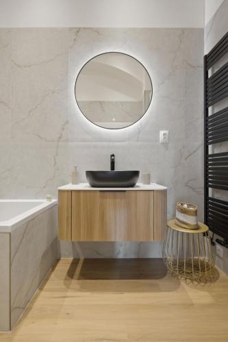 a bathroom with a sink and a mirror at Primavera - Castle view apartments in Prague