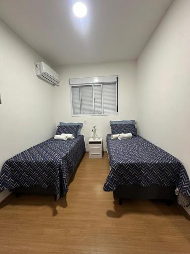 a room with two beds and a window at Apartamento completo em Ponta de Campina, 2 quartos, piscina, academia e Wi-Fi in Cabedelo