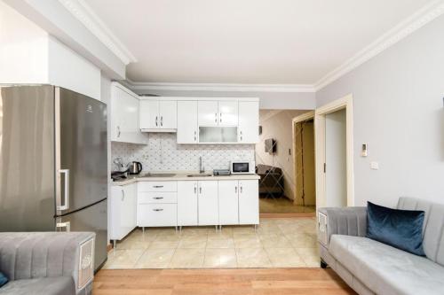 a kitchen and living room with white cabinets and a couch at İstanbul Amoria Guest House in Istanbul
