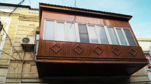 drewniany budynek z oknami z boku budynku w obiekcie AR Hostel w mieście Baku