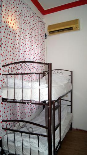 dwa łóżka piętrowe w pokoju z tapetą w kropki w obiekcie AR Hostel w mieście Baku