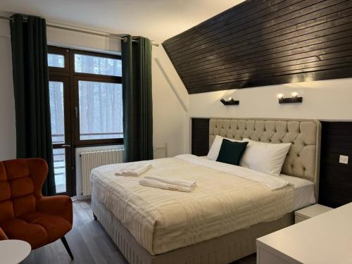 a bedroom with a large bed and a chair at Goldel Resort in Delčevo