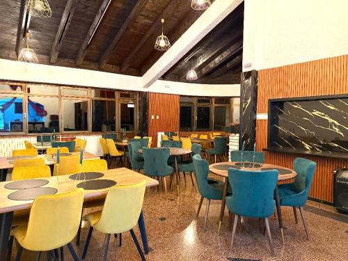 a dining room with tables and chairs and a chalkboard at Goldel Resort in Delčevo