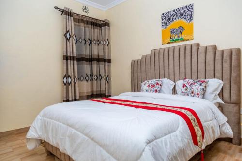 a bedroom with a large bed with a large headboard at Legacy by Fralec in Nyeri